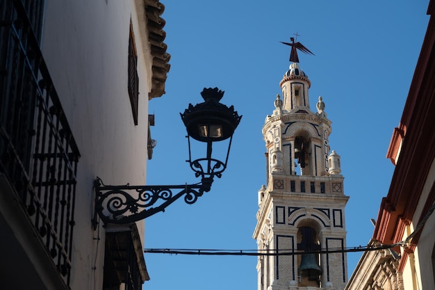 Tower of a church in Ecija Andalusia with a lamppost in the foreground