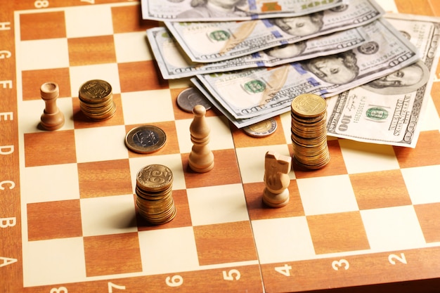 Фото Башня монеты и доллары на шахматной доске, деньги, концепция финансирования
