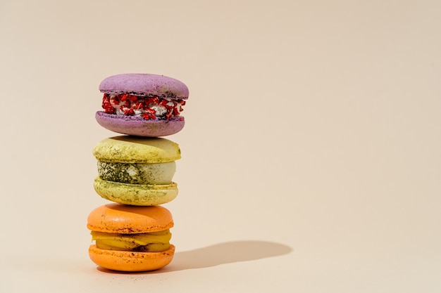Tower of colorful macaron or macaroon on beige background