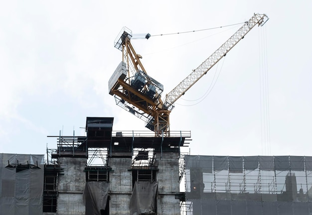 Tower construction crane on rooftop building construction site