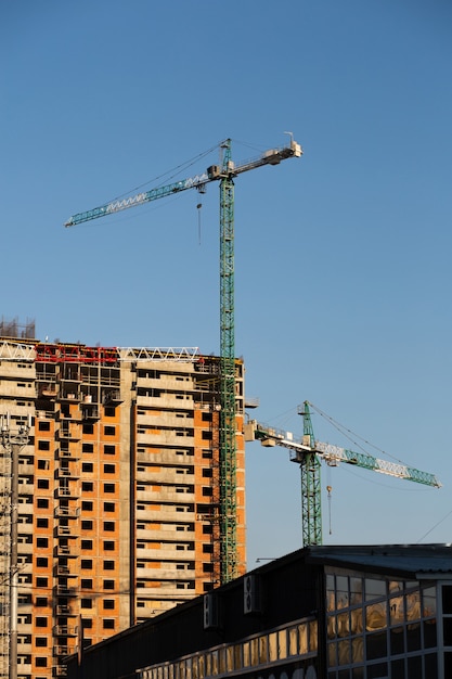 Gru a torre sullo sfondo di un cantiere in giornata di sole