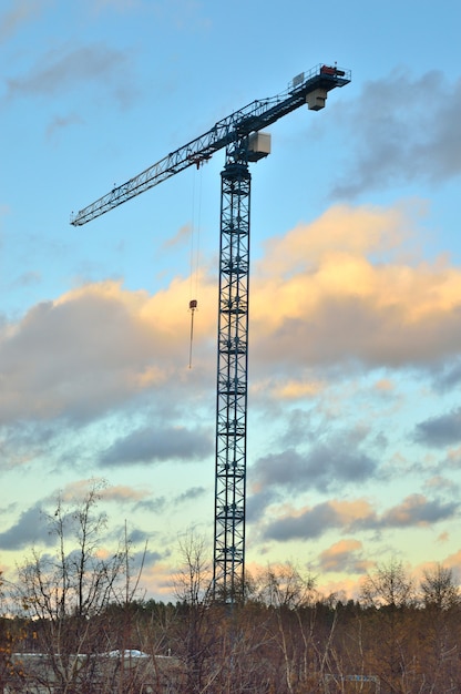 Tower crane on a rack against a background of beautiful clouds.