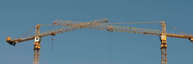 Tower cranes at construction site and city background