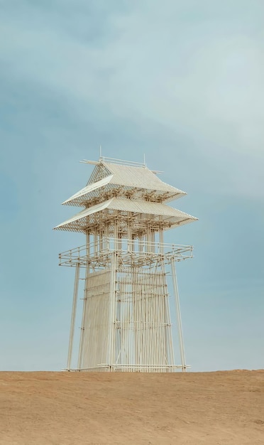 A tower with a white roof and a blue sky in the background.