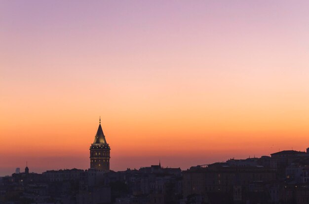 Photo a tower with a yellow and orange sunset in the background.