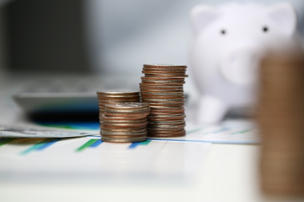 Towers of coins on background office.