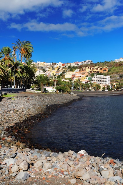 Town on mountain at san sebastian de la gomera by sea against blue sky