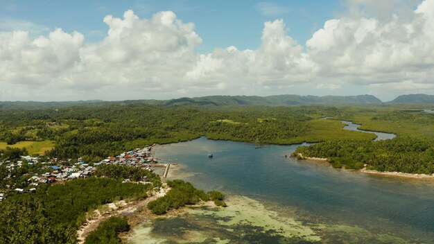 Foto città in zone umide e mangrovie sulla costa dell'oceano da sopra l'isola di siargao filippine