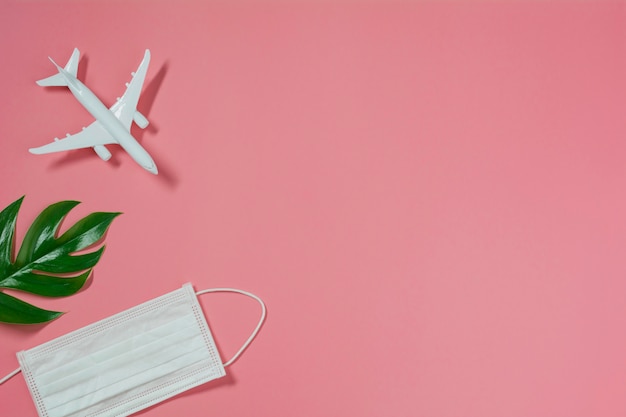 A toy airplane with medical mask for protecting virus and dust. Travel and protection concept.