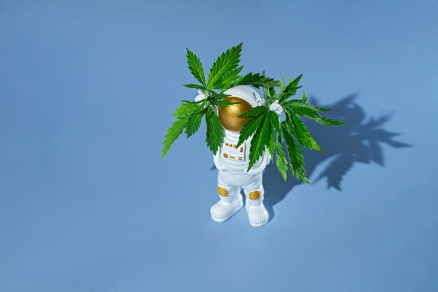 大麻と一緒に立って手を上げて宇宙服を着たおもちゃの宇宙飛行士