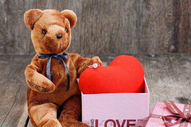 Toy bear doll and the jewelry ring with red heart. 