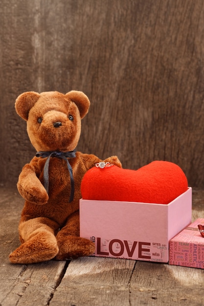 Toy bear doll and the jewelry ring with red heart. 