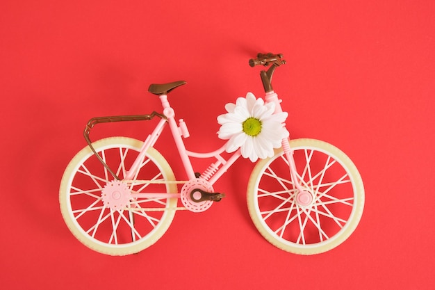 Toy bicycle on a red background copy space