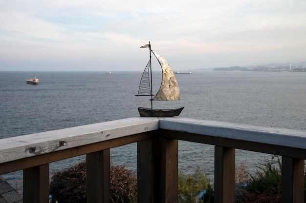 Foto barca giocattolo su una ringhiera contro il mare