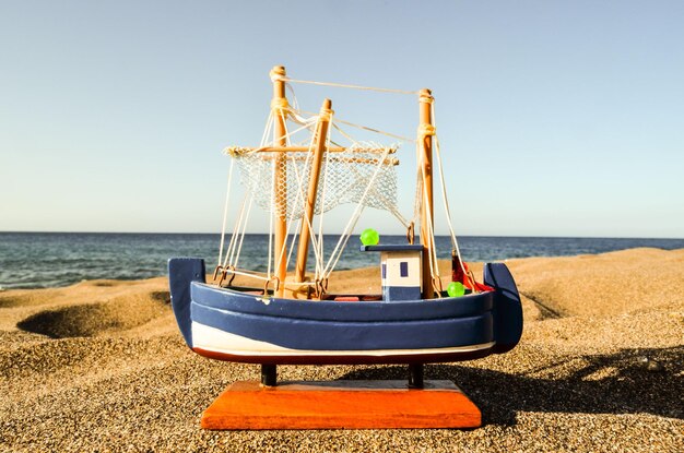 Photo toy boat on the sand beach