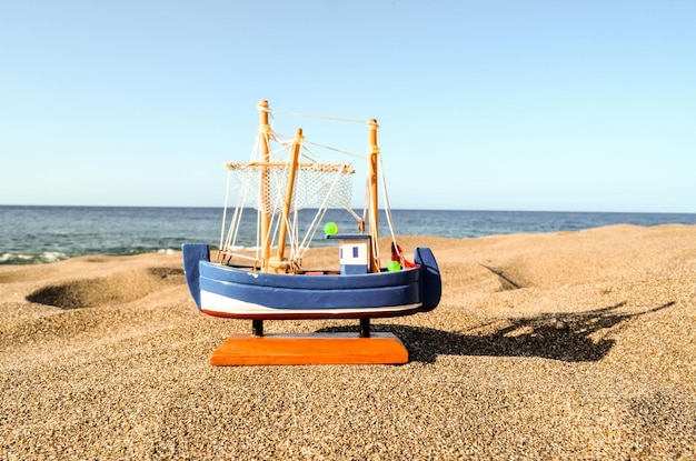 Photo toy boat on the sand beach