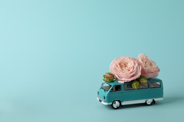 Toy bus with pink roses on blue background