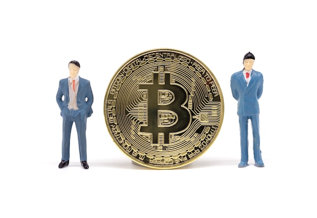 Toy businessman and Bitcoin on white background