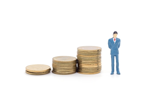 Toy businessman and coins on white background