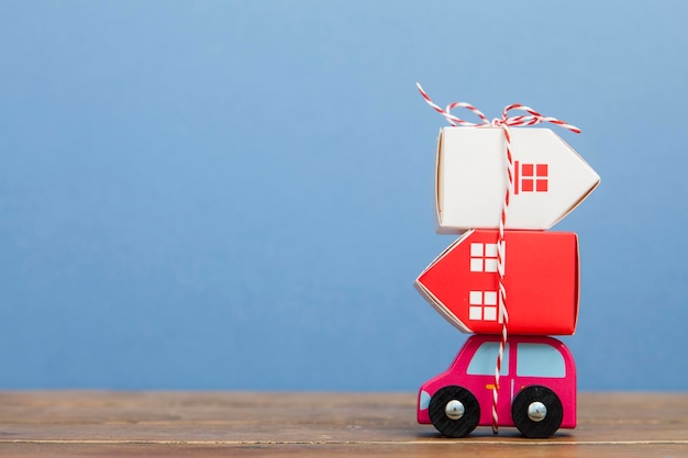 Toy car carrying a stack of houses Moving house concept