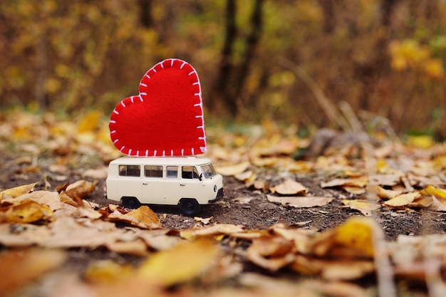 Toy car minivan lucky on the roof of a large red heart 