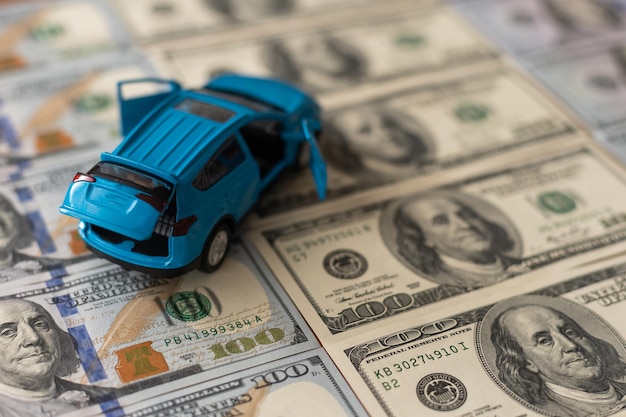 Toy car on one hundred dollar bills.