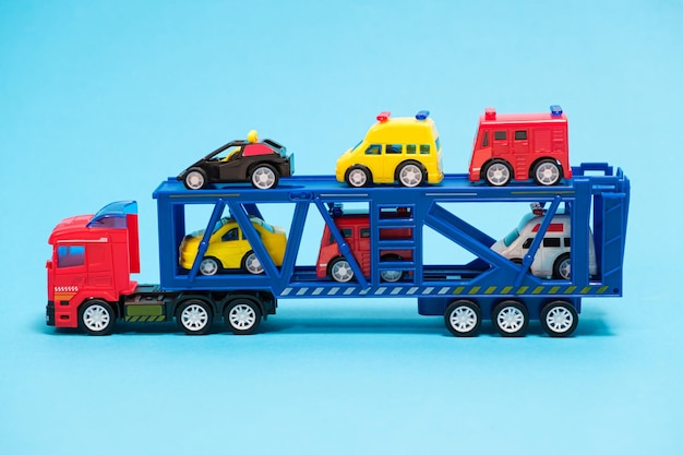 Toy car transporter with cars on a blue background