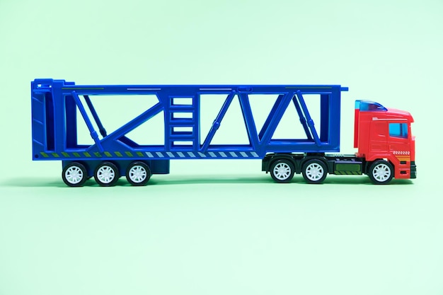 Toy car transporter with cars on a green background