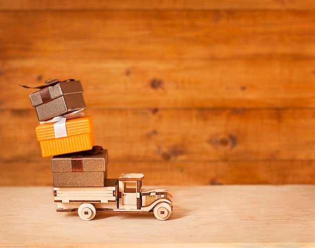 toy car with gifts on wooden background