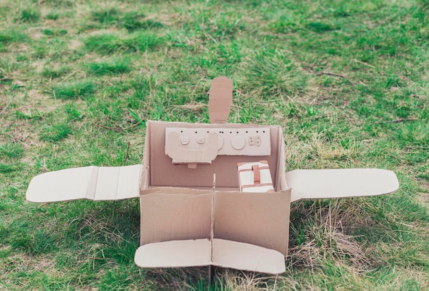 Toy cardboard plane in the field. focus on the steering\
wheel