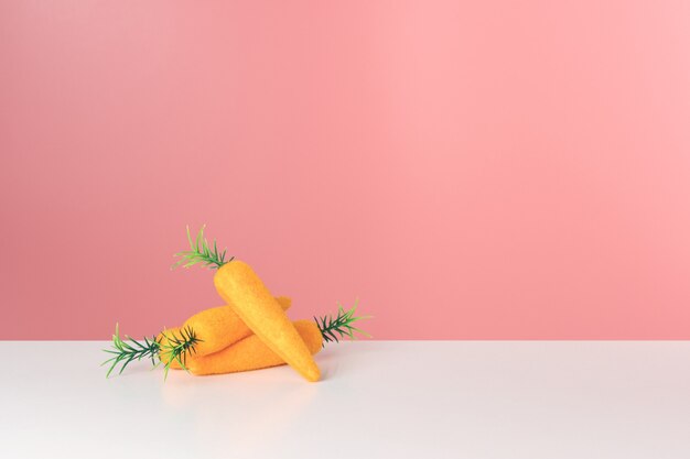 Toy carrots on white table.