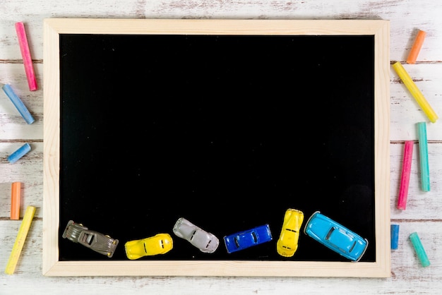 Toy cars and blackboard on table