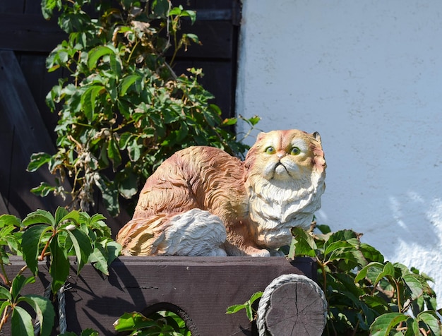 Toy cat on the fence Statuette of a cat in plaster and plastic on the fence