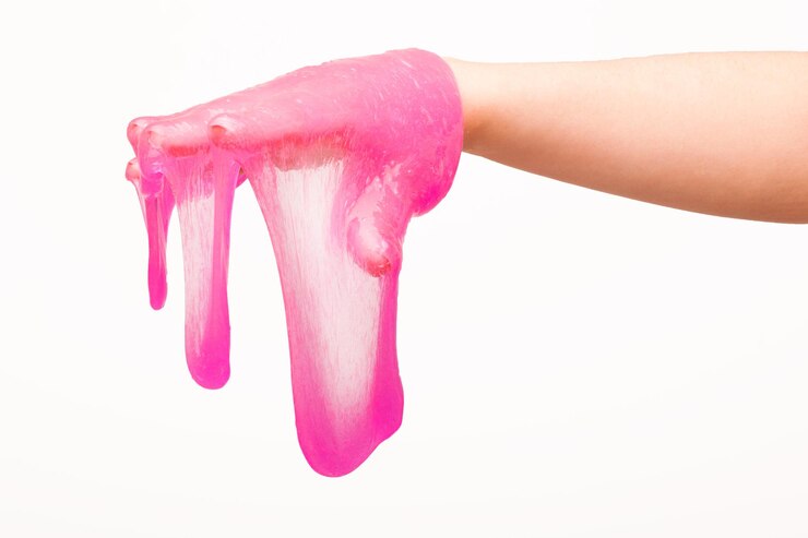 Photo a toy for children mucus and liquid flowing on hand on a white background