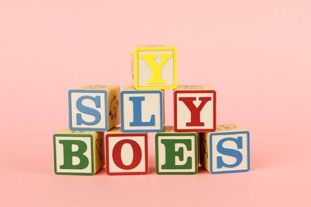 Toy colored cubes with letters on pink 