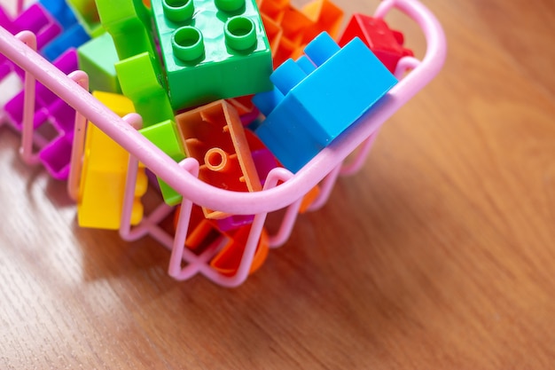 Toy colorful plastic blocks on wooden floor background