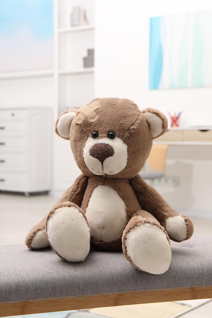 toy cute bear with sticking plaster indoors