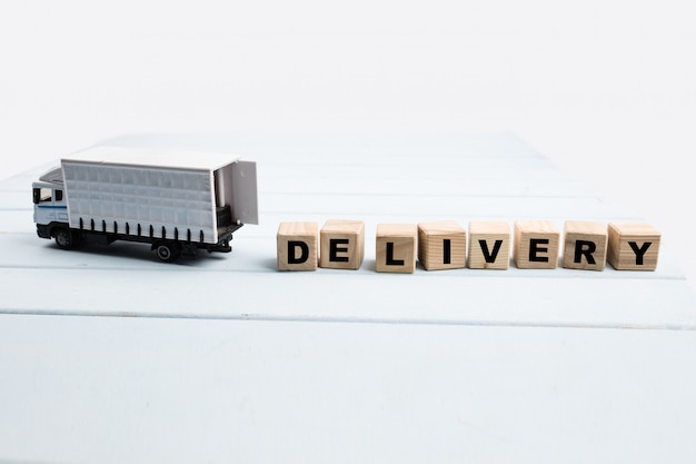 Toy delivery truck with boxes and wooden cubes on blue background