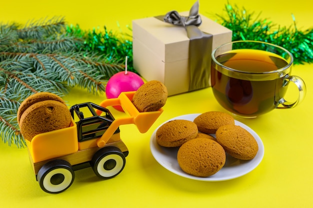 A toy excavator delivers cookies to celebrate children's Christmas.