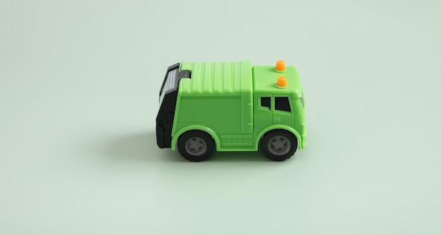 Toy garbage truck and recycle text on a green background