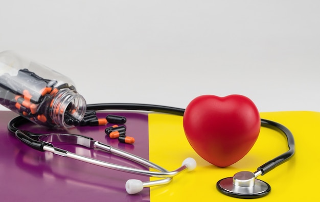 Toy heart and stethoscope on a colored background Concept healthcare Cardiology care of the heart