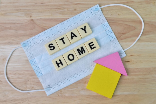 Photo toy house face mask and square letters with text stay home