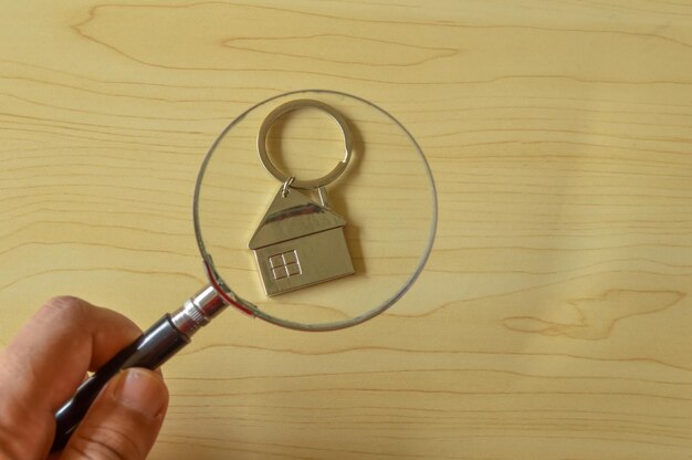 Photo toy house and magnifying glass the concept of finding a new home to buy or property to invest