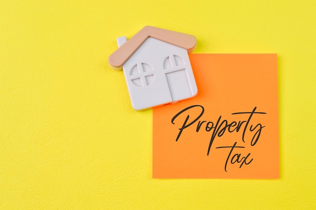 PROPERTY TAX 부동산 개념으로 쓰여진 장난감 집과 메모장