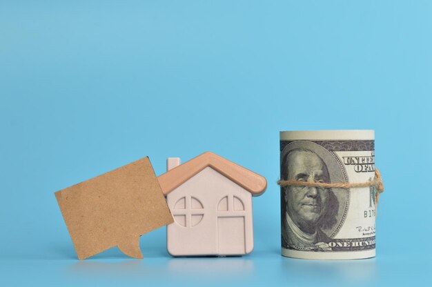 おもちゃの家のお金の紙幣と、HOME BUYING TIPS が書かれた吹き出しノート