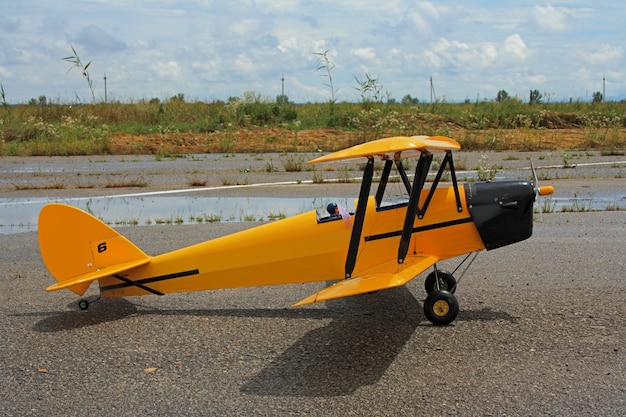 Toy model of a biplane airplane stands on a hard surface