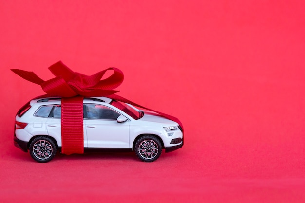 Toy new car gift with bow on red