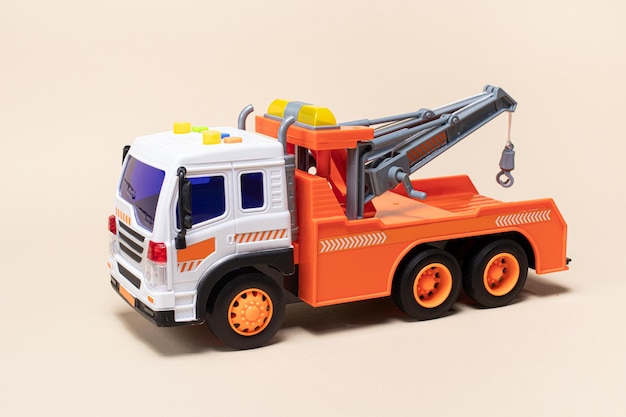 Toy orange tow truck on beige background