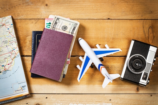 A toy plane a passport and a boarding pass on a pink background