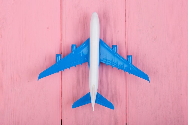 Игрушечный самолет на розовом деревянном фоне Вид сверху